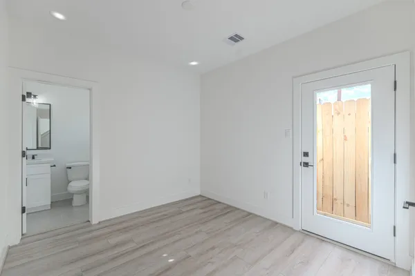 wooden floor in an empty room with a bathroom