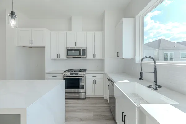 a kitchen with stainless steel appliances granite countertop a sink stove and refrigerator