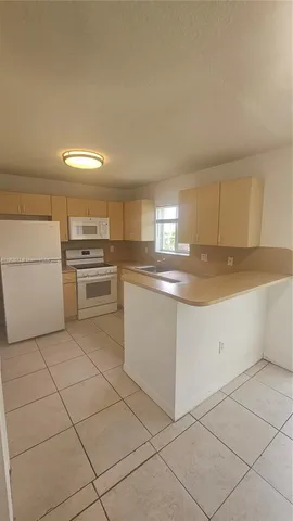 a kitchen with cabinets and white stainless steel appliances
