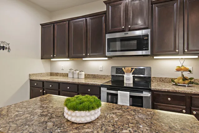 a kitchen with stainless steel appliances a stove a microwave and sink