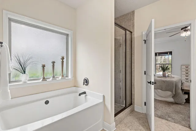 a bathroom with a tub a sink and a large mirror