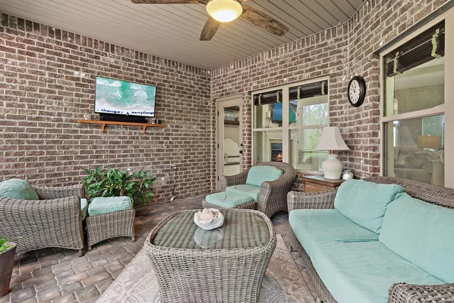a view of a patio with couches chairs and wooden floor