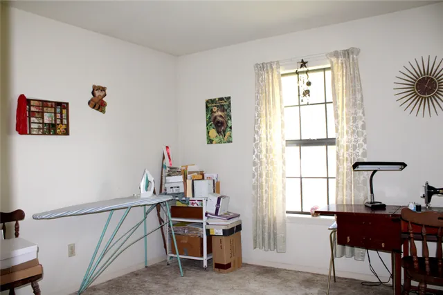 a view of a workspace with furniture and a window
