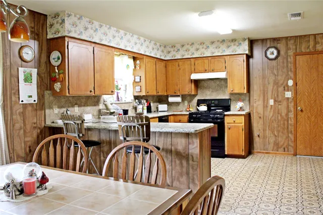 a kitchen with sink refrigerator dining table and chairs