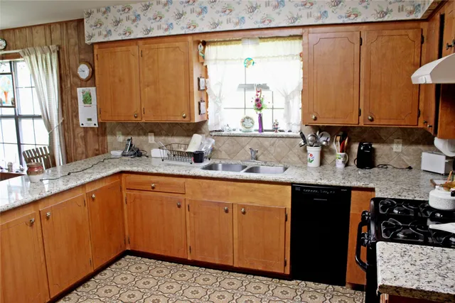 a kitchen with stainless steel appliances a sink dishwasher refrigerator and cabinets