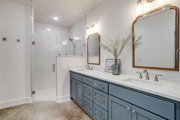 a bathroom with double sink and a mirror