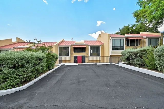 a view of a house with a yard and potted plants