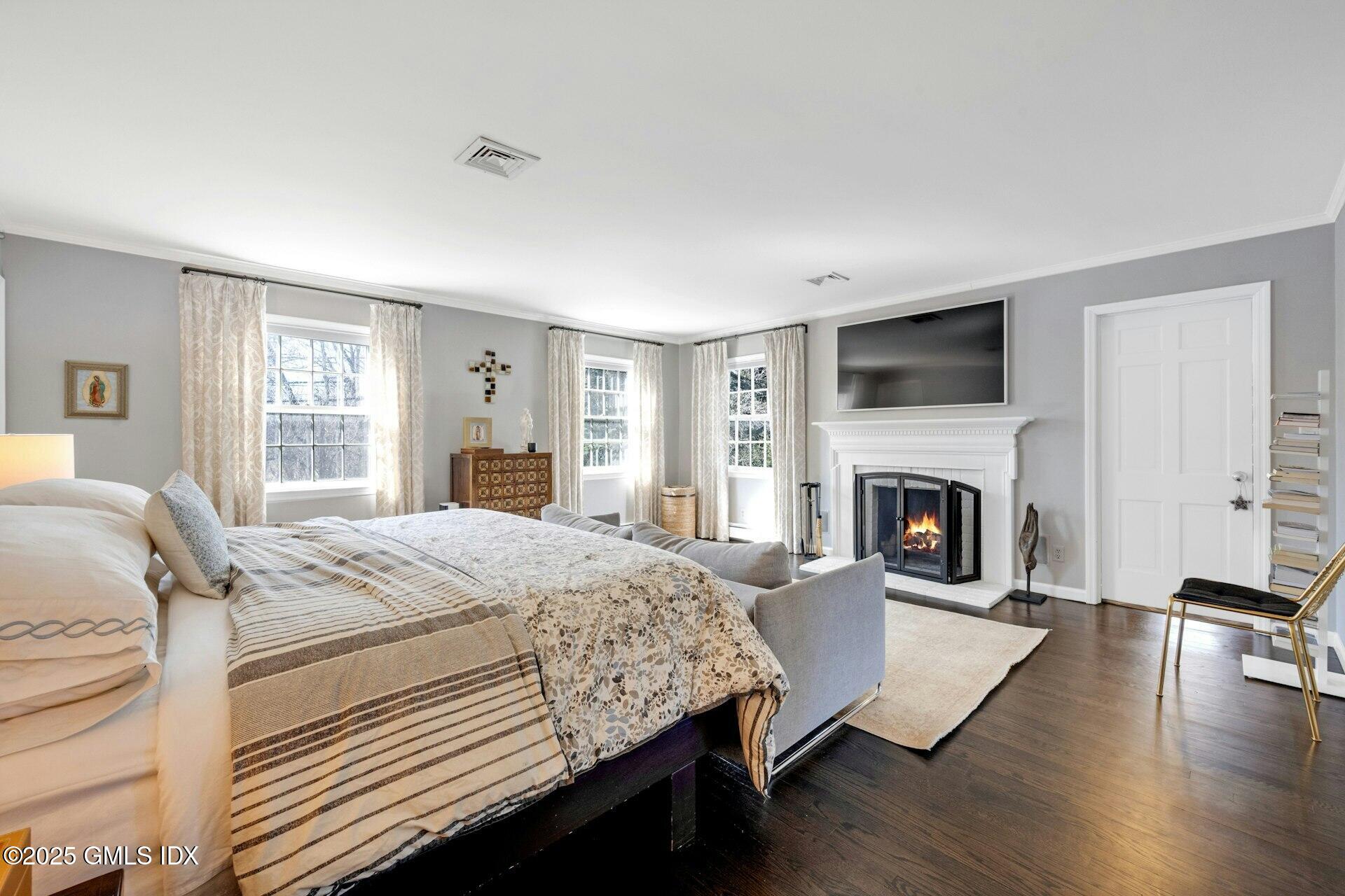 1 Ivanhoe Lane Greenwich, CT 06830 - Photo 12 of 27 a bedroom with a large bed a fireplace and a window