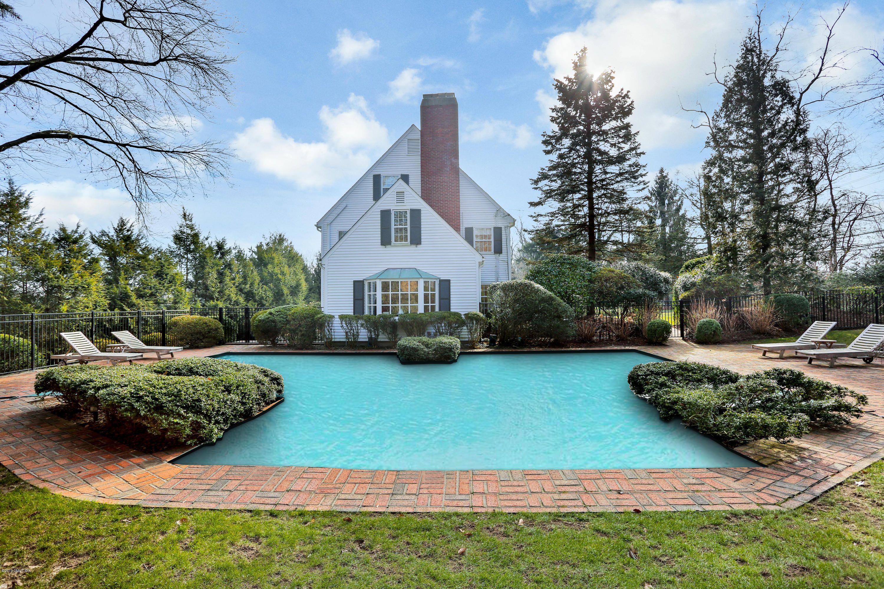 1 Ivanhoe Lane Greenwich, CT 06830 - Photo 22 of 27 a front view of a house with a garden and yard