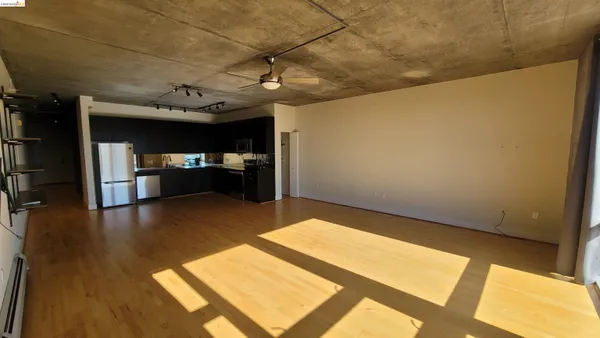 a large kitchen with sink a refrigerator and wooden floor