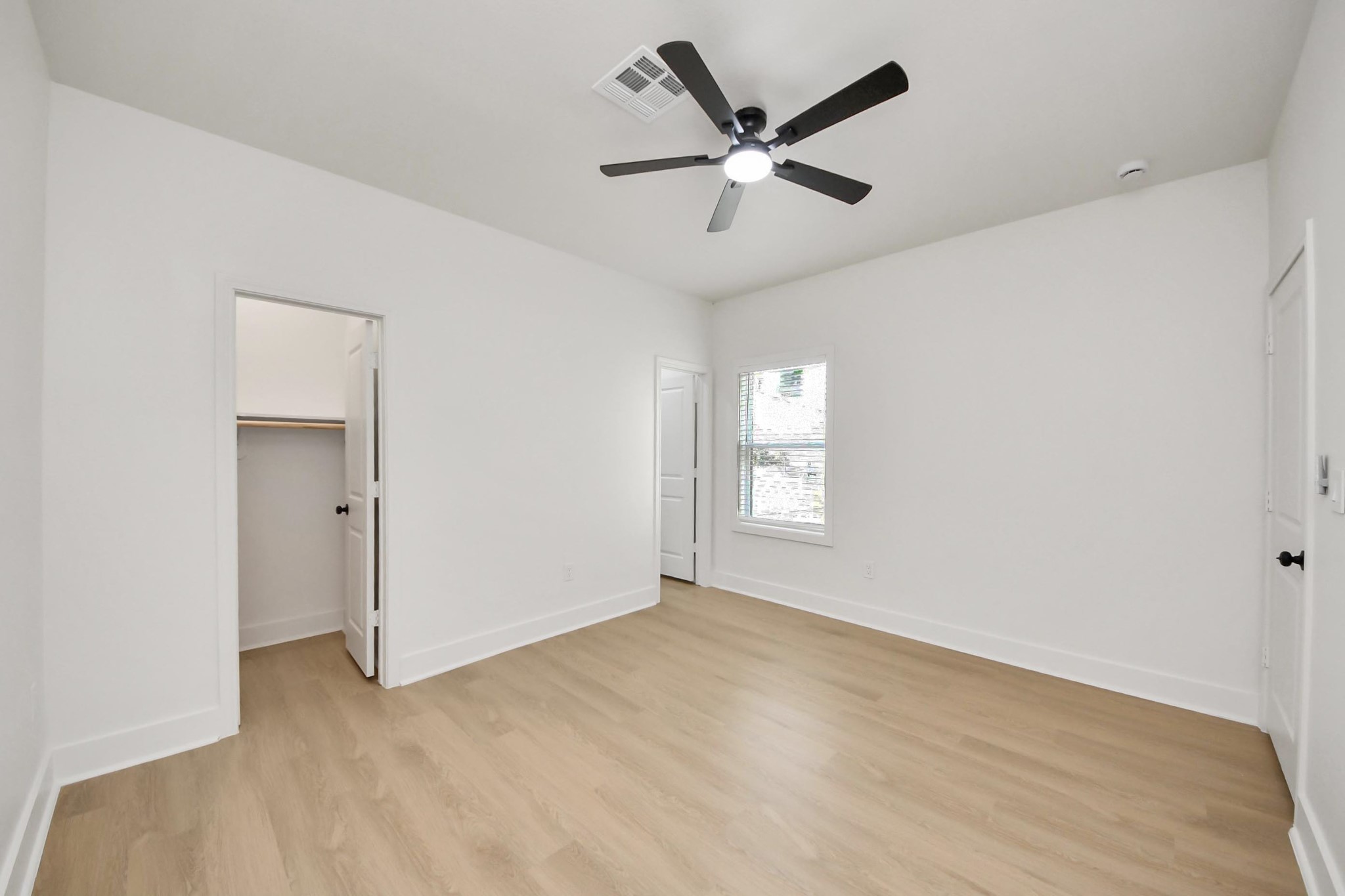 5226 Ricky Street Houston, TX 77033 - Photo 30 of 50 a view of a big room with wooden floor and windows in ceiling fan