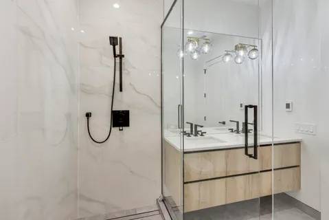 a bathroom with a sink a mirror a vanity and a shower