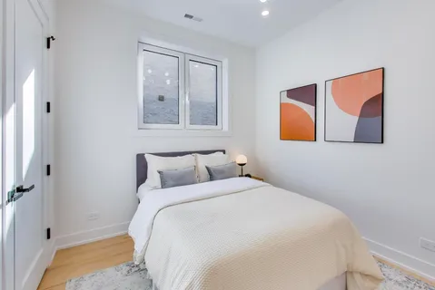 a bedroom with a bed and painting on the wall