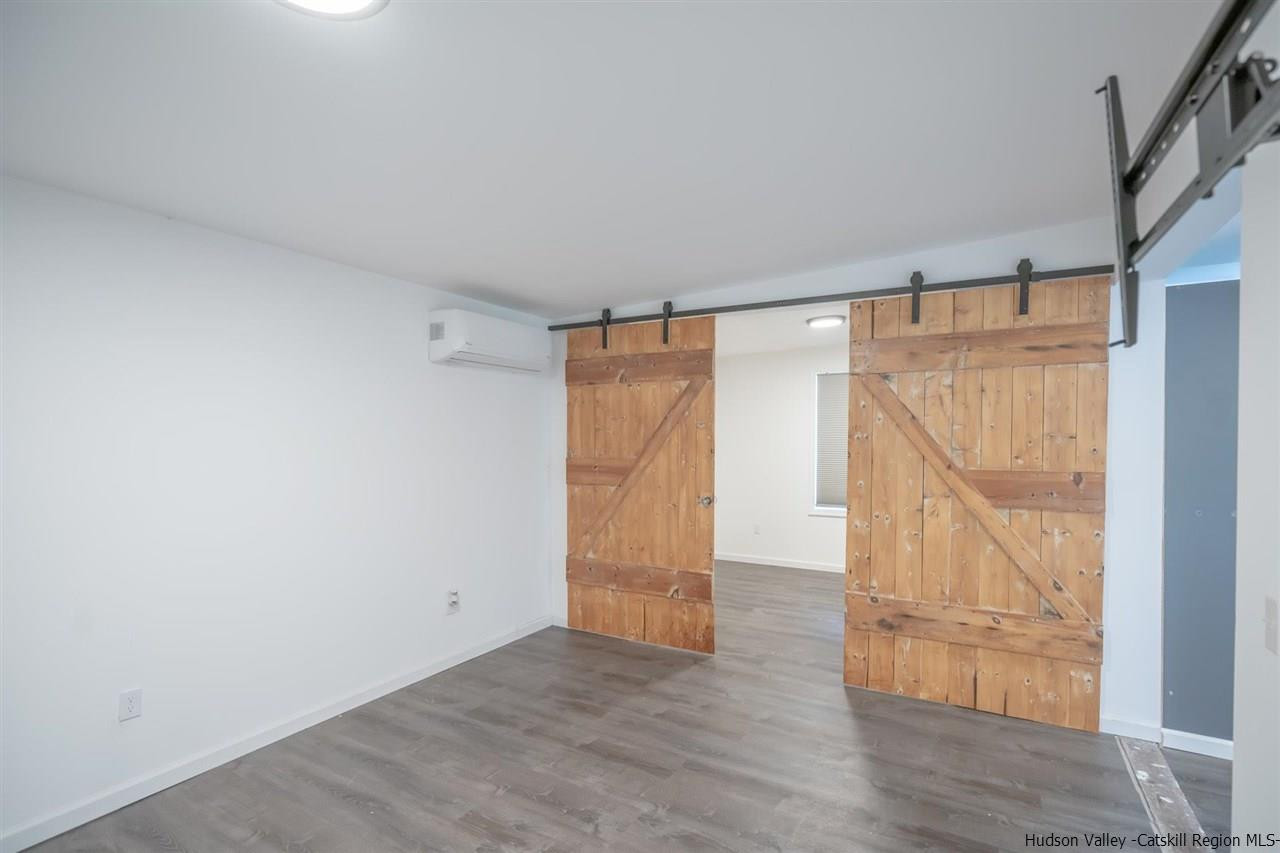 23 Spaulding Lane Saugerties, NY 12477 - Photo 24 of 35 an empty room with wooden floor and door