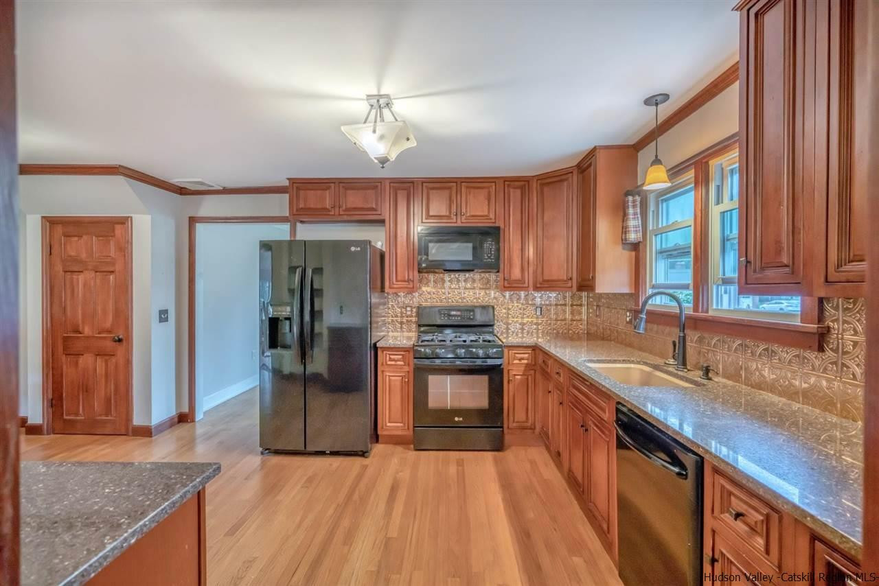 23 Spaulding Lane Saugerties, NY 12477 - Photo 9 of 35 a kitchen with stainless steel appliances granite countertop a refrigerator a sink dishwasher a stove and a dining table with wooden floor