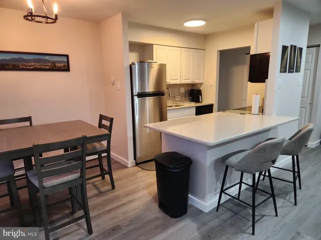 a kitchen with stainless steel appliances refrigerator dining table and chairs