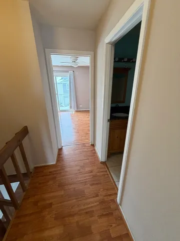 a view of a hallway with wooden floor and staircase