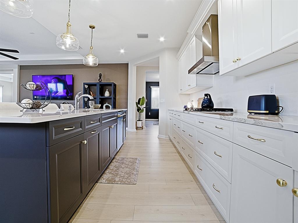 1599 Bellagio Loop Tavares, FL 32778 - Photo 11 of 75 a kitchen with stainless steel appliances kitchen island granite countertop a sink and cabinets