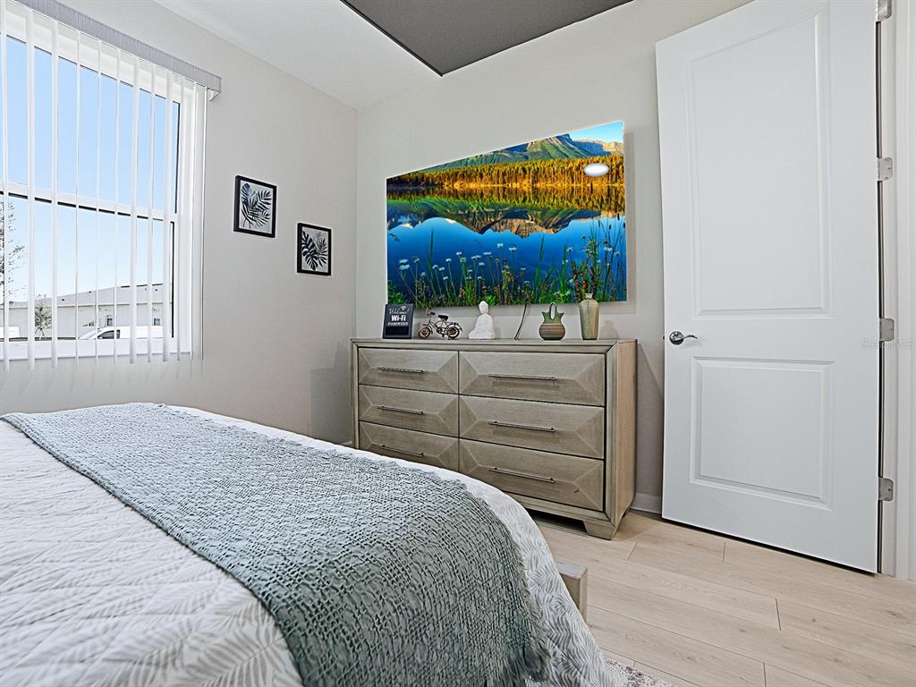 1599 Bellagio Loop Tavares, FL 32778 - Photo 22 of 75 a bedroom with a bed and flat screen tv