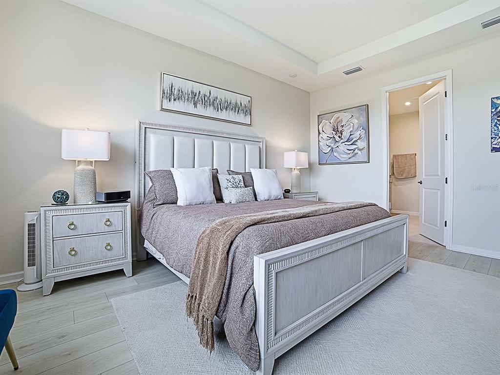 1599 Bellagio Loop Tavares, FL 32778 - Photo 26 of 75 a bedroom with a bed and a night stand