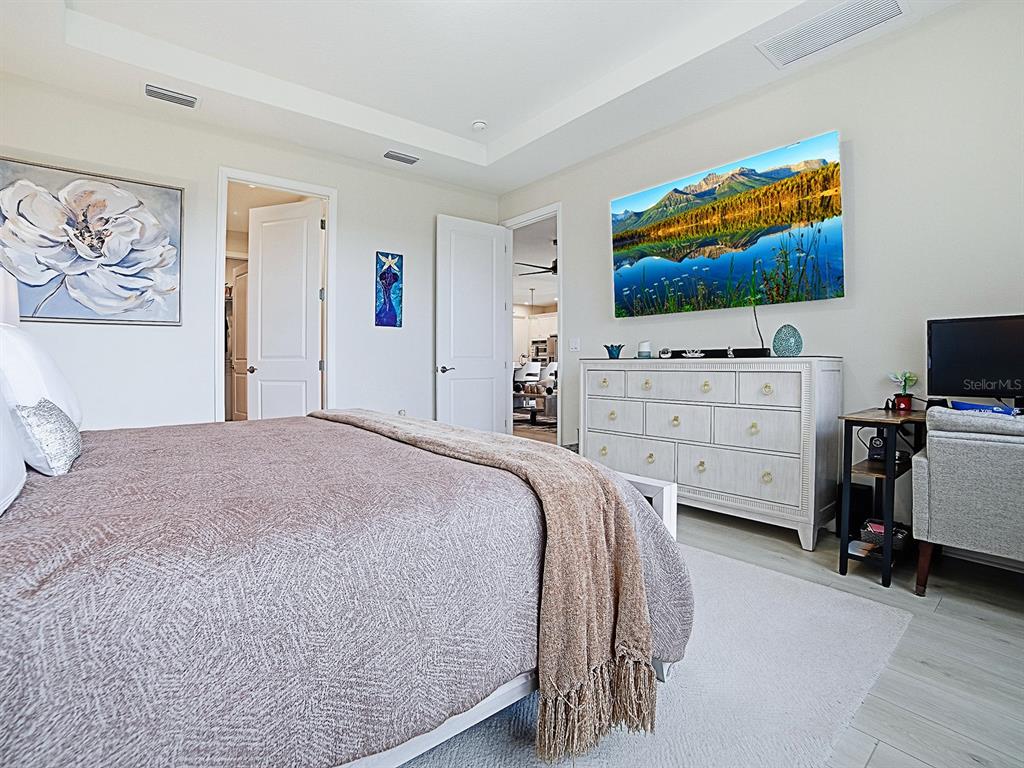 1599 Bellagio Loop Tavares, FL 32778 - Photo 27 of 75 a bedroom with a bed and flat screen tv