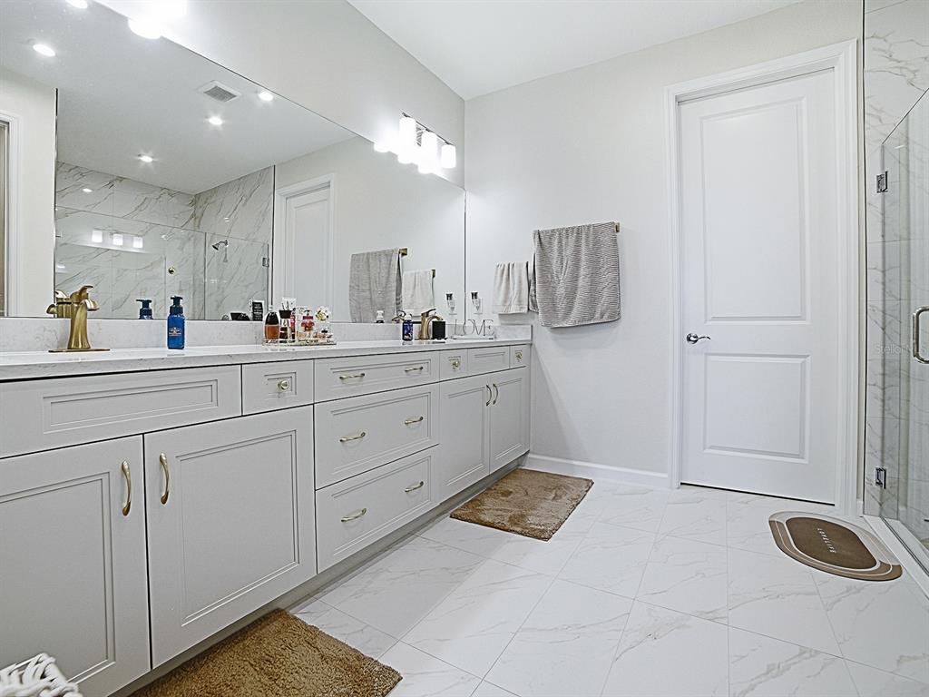 1599 Bellagio Loop Tavares, FL 32778 - Photo 29 of 75 a spacious bathroom with a sink and a mirror