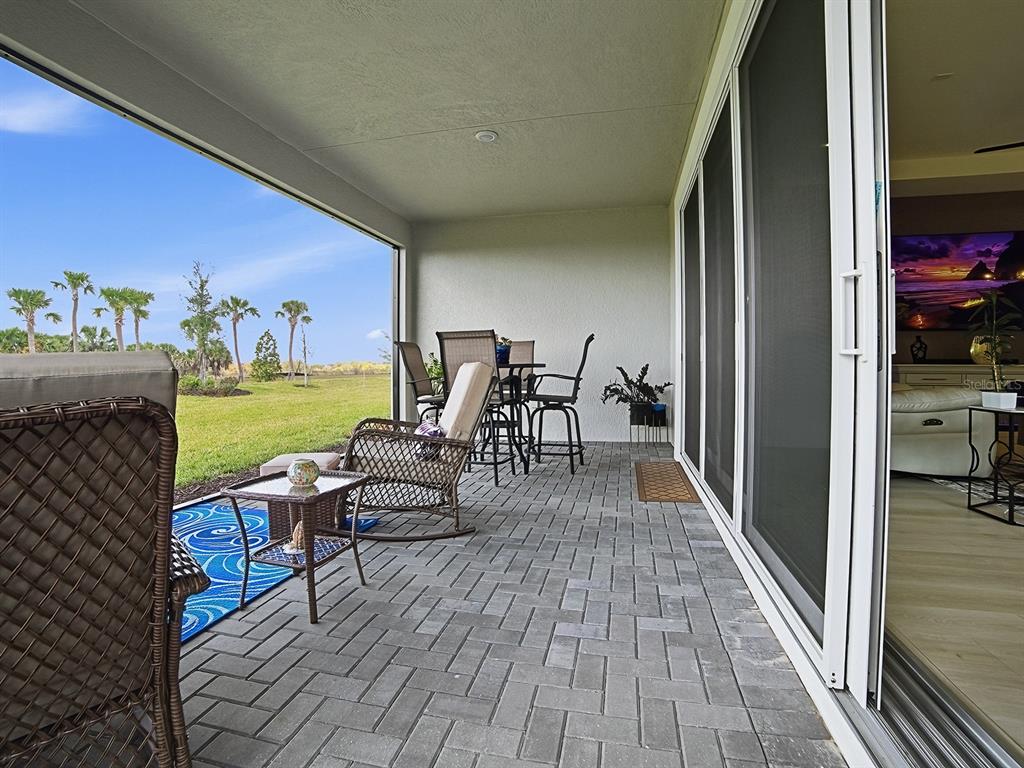 1599 Bellagio Loop Tavares, FL 32778 - Photo 33 of 75 a view of a patio with dining table and chairs with wooden floor