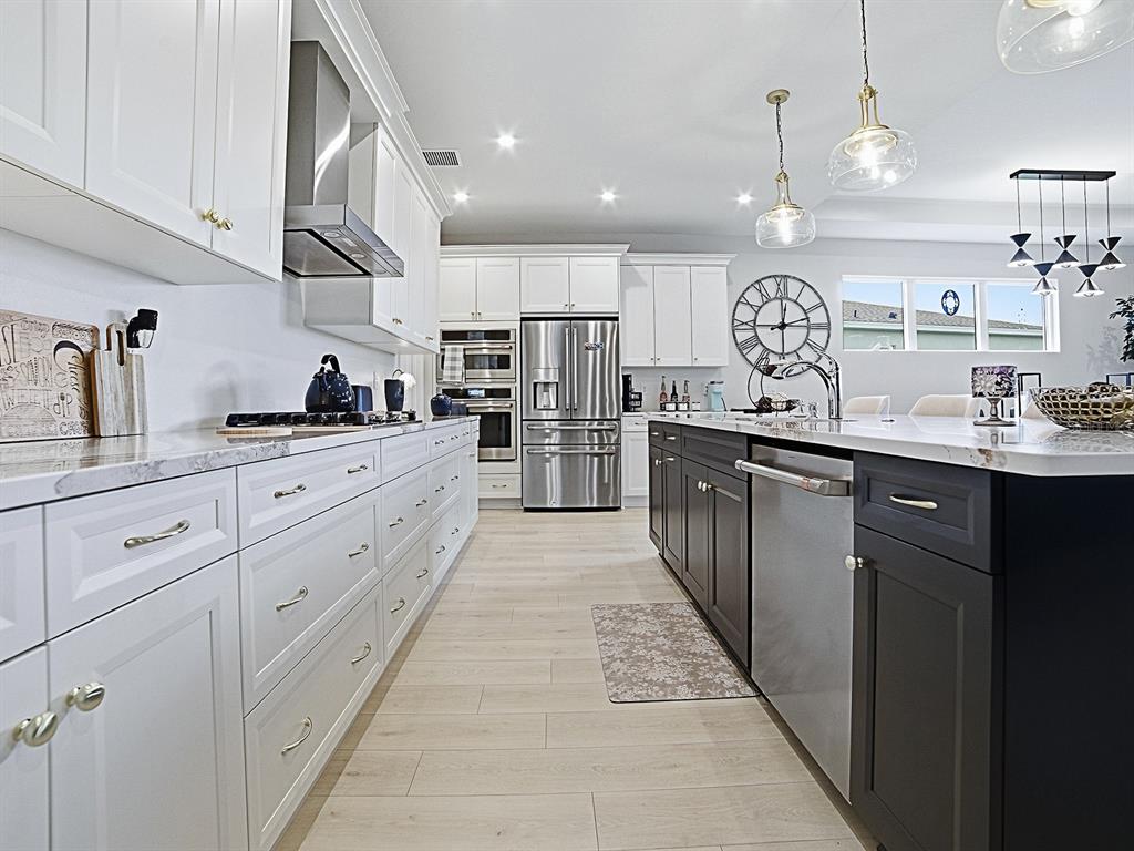 1599 Bellagio Loop Tavares, FL 32778 - Photo 7 of 75 a kitchen with stainless steel appliances kitchen island granite countertop a sink and cabinets