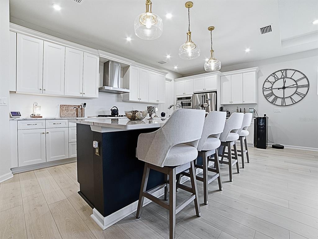 1599 Bellagio Loop Tavares, FL 32778 - Photo 9 of 75 a kitchen with stainless steel appliances granite countertop a table chairs sink and cabinets