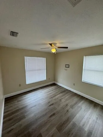 a view of empty room with wooden floor