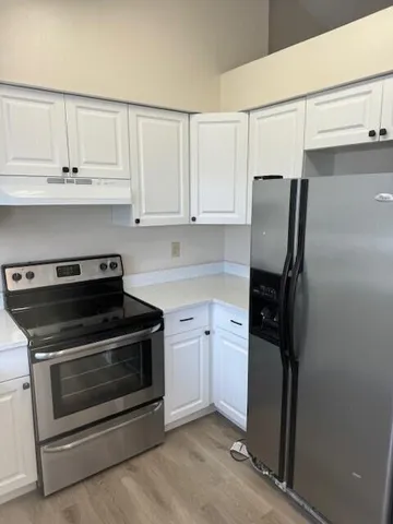 a kitchen with refrigerator stove and cabinets