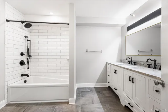 a bathroom with a bathtub a shower a sink and a mirror