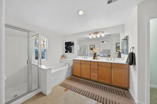 a spacious bathroom with a double vanity sink a mirror and a bathtub