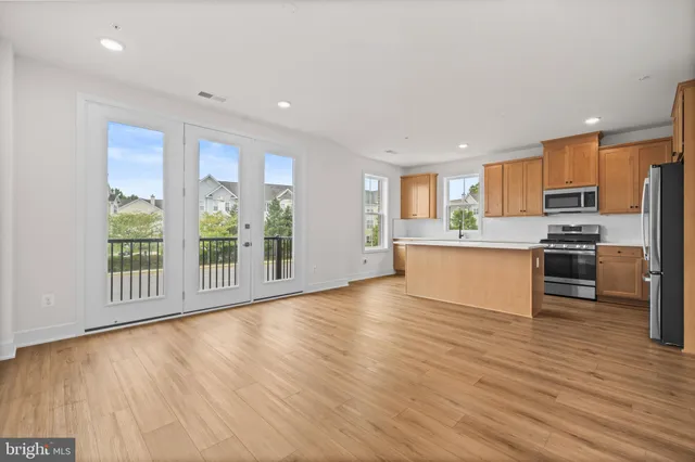 a kitchen with stainless steel appliances a refrigerator a stove top oven and a large window