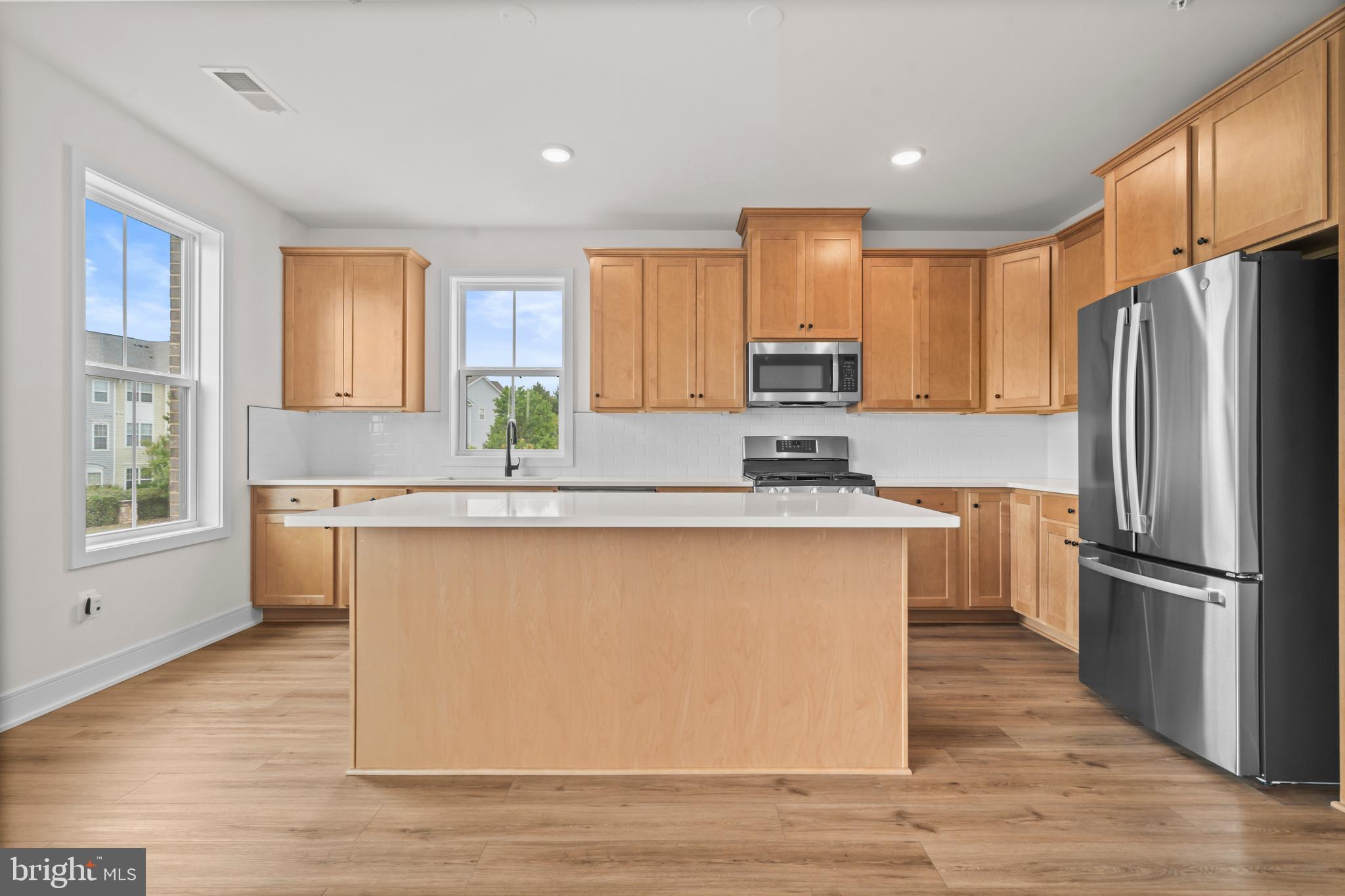 43382 Farringdon Square Broadlands, VA 20148 - Photo 13 of 34 a kitchen with stainless steel appliances granite countertop a refrigerator a stove a sink dishwasher and a refrigerator with wooden floor