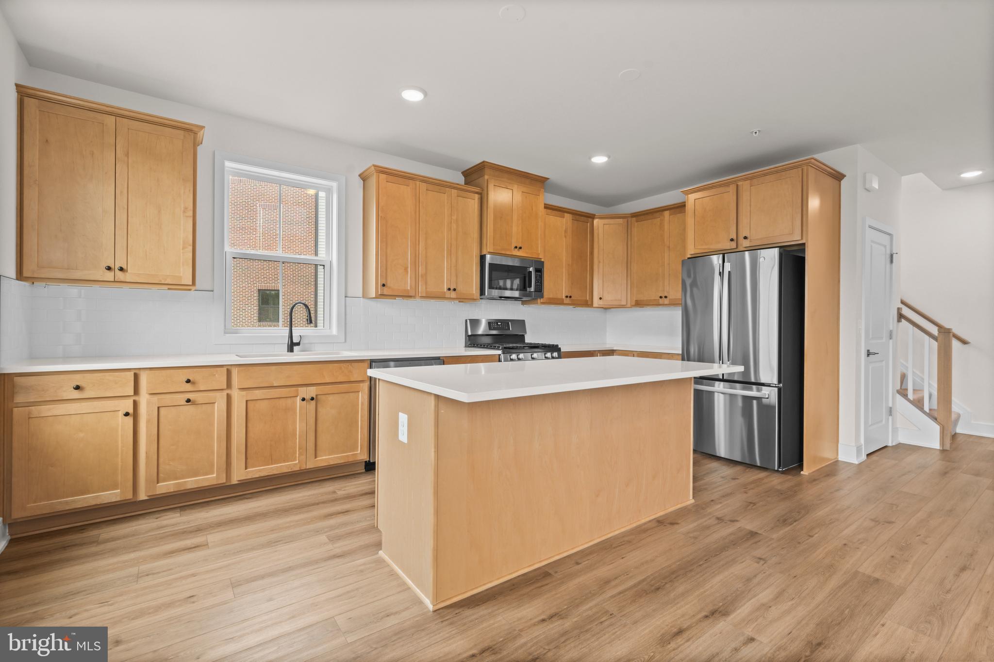 43382 Farringdon Square Broadlands, VA 20148 - Photo 14 of 34 a kitchen with stainless steel appliances granite countertop a refrigerator a sink dishwasher a stove top oven a refrigerator with white cabinets and wooden floor