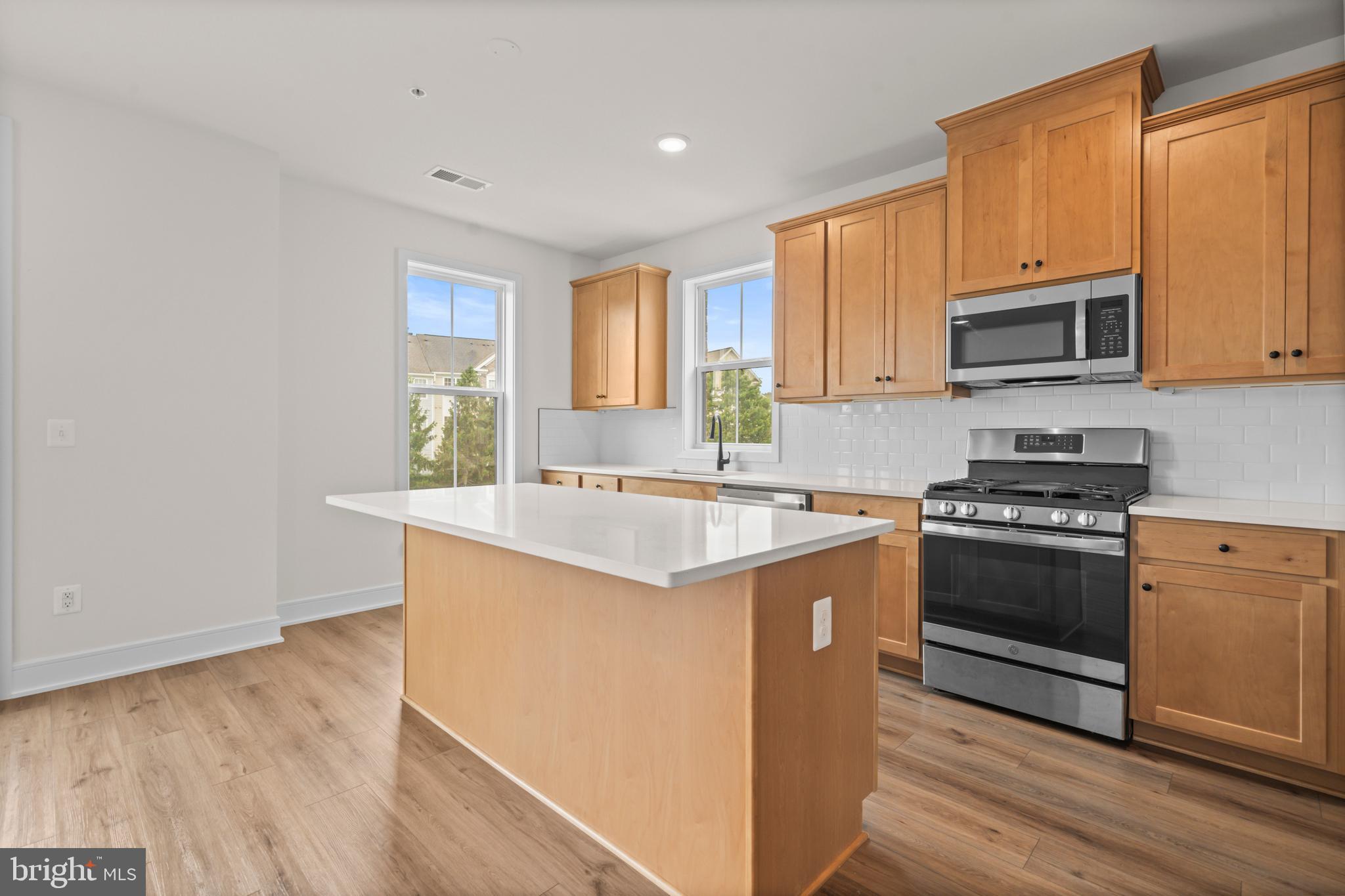 43382 Farringdon Square Broadlands, VA 20148 - Photo 15 of 34 a kitchen with stainless steel appliances granite countertop a stove a sink and a microwave