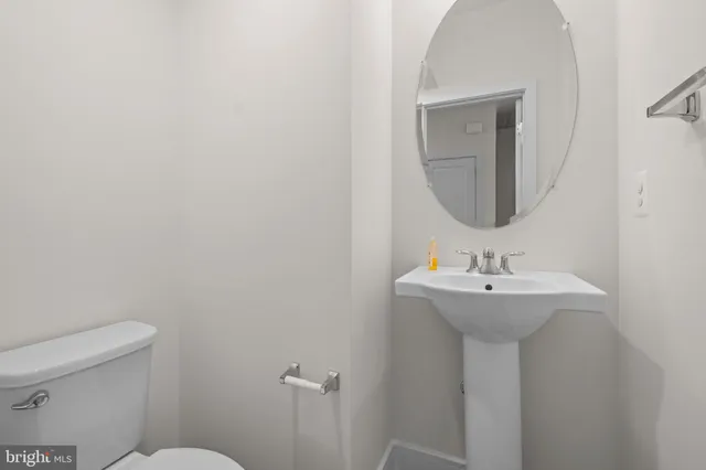 a bathroom with a sink a mirror and toilet