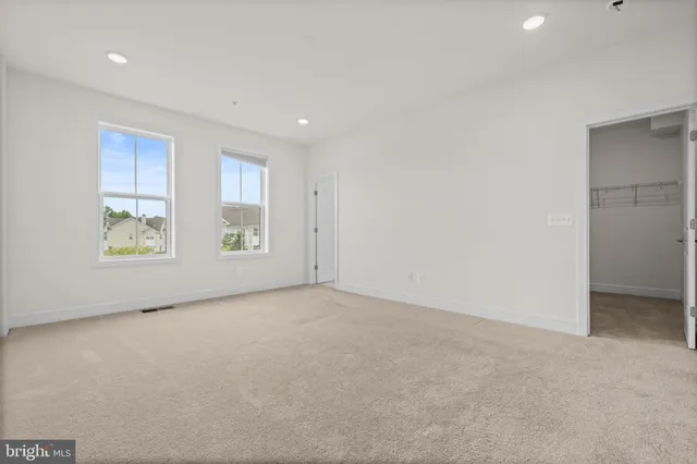 an empty room with windows and closet