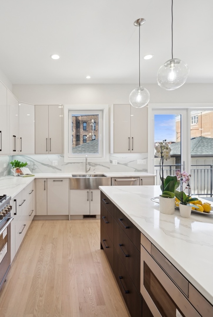 967 East 62nd Street, Unit 2 Chicago, IL 60637 - Photo 4 of 8 a large kitchen with stainless steel appliances a sink a stove a counter space and a window