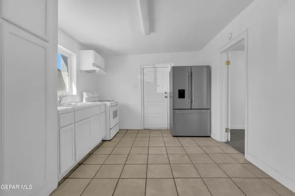a kitchen with white cabinets and sink