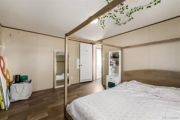 a bedroom with a bed and wooden floor