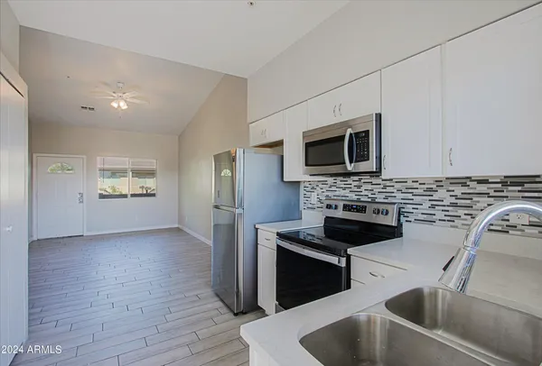 a kitchen that has a sink and a stove top oven