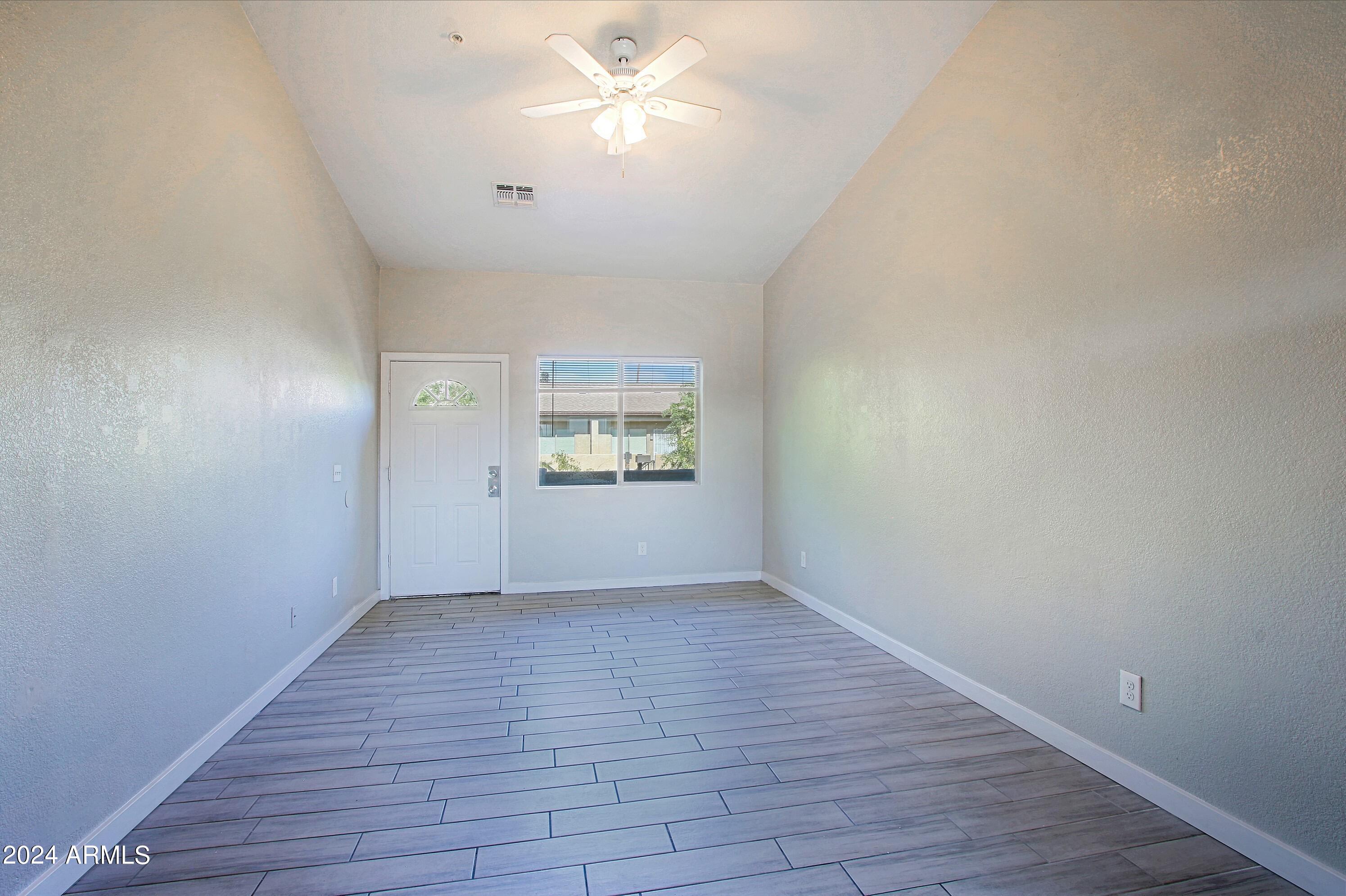 1614 West Purdue Avenue, Unit 102 Phoenix, AZ 85021 - Photo 5 of 11 wooden floor in an empty room with a window