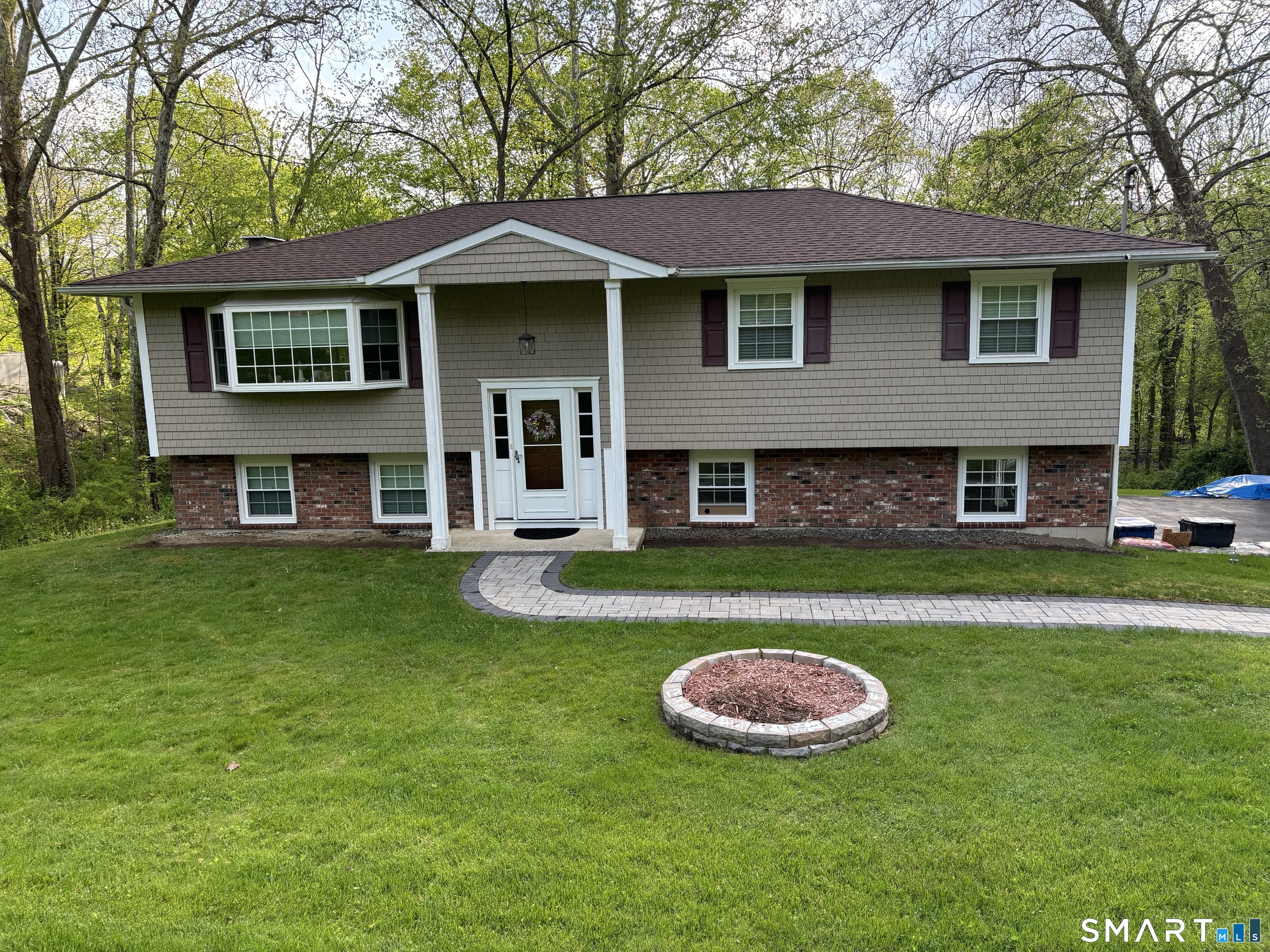 22 Prospect Drive Brookfield, CT 06804 - Photo 1 of 1 a view of a brick house with a yard table and chairs