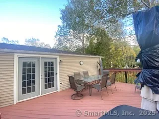 a view of a roof deck with table and chairs and wooden floor