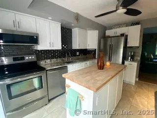 a kitchen with stainless steel appliances granite countertop a sink a stove and a microwave