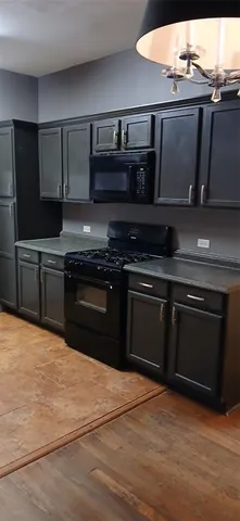 a kitchen with granite countertop stainless steel appliances and wooden cabinets