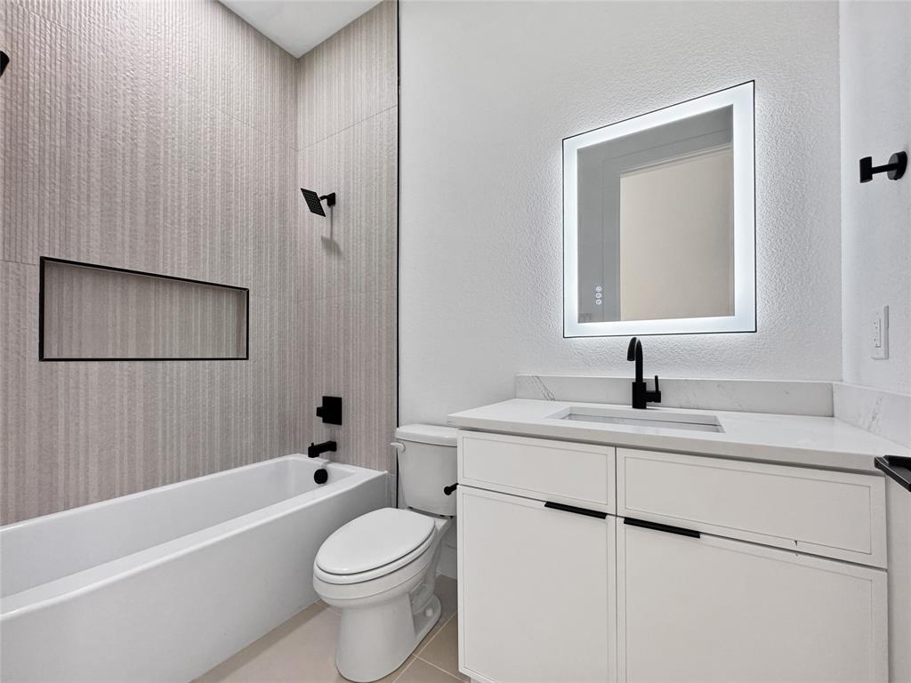 4623 Luzon Street Dallas, TX 75216 - Photo 12 of 17 Bathroom with shower combination, vanity, a textured wall, and light tile patterned floors