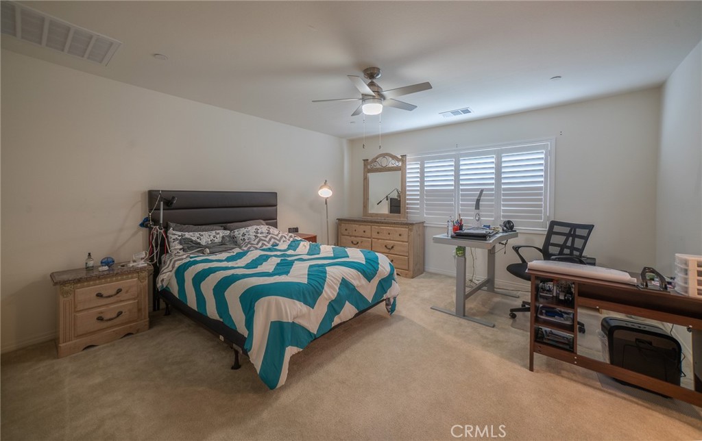 1099 Little Leaf Street Calimesa, CA 92320 - Photo 13 of 32 a bedroom with a bed and a chandelier